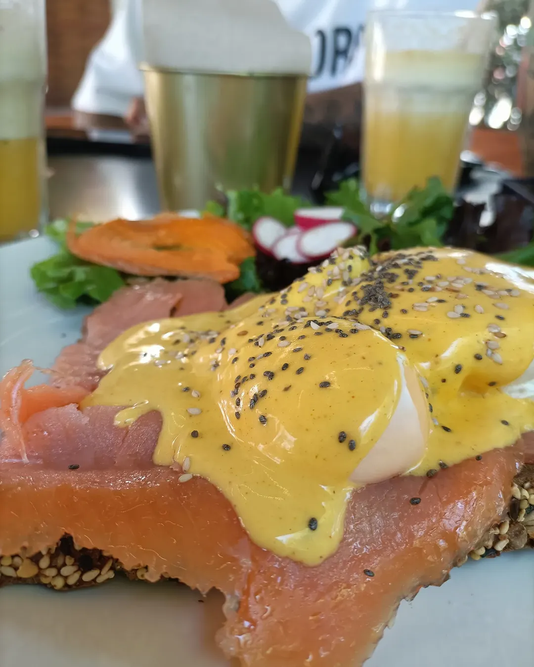 Ovos benedict com salmão e molho amarelo sobre pão escuro