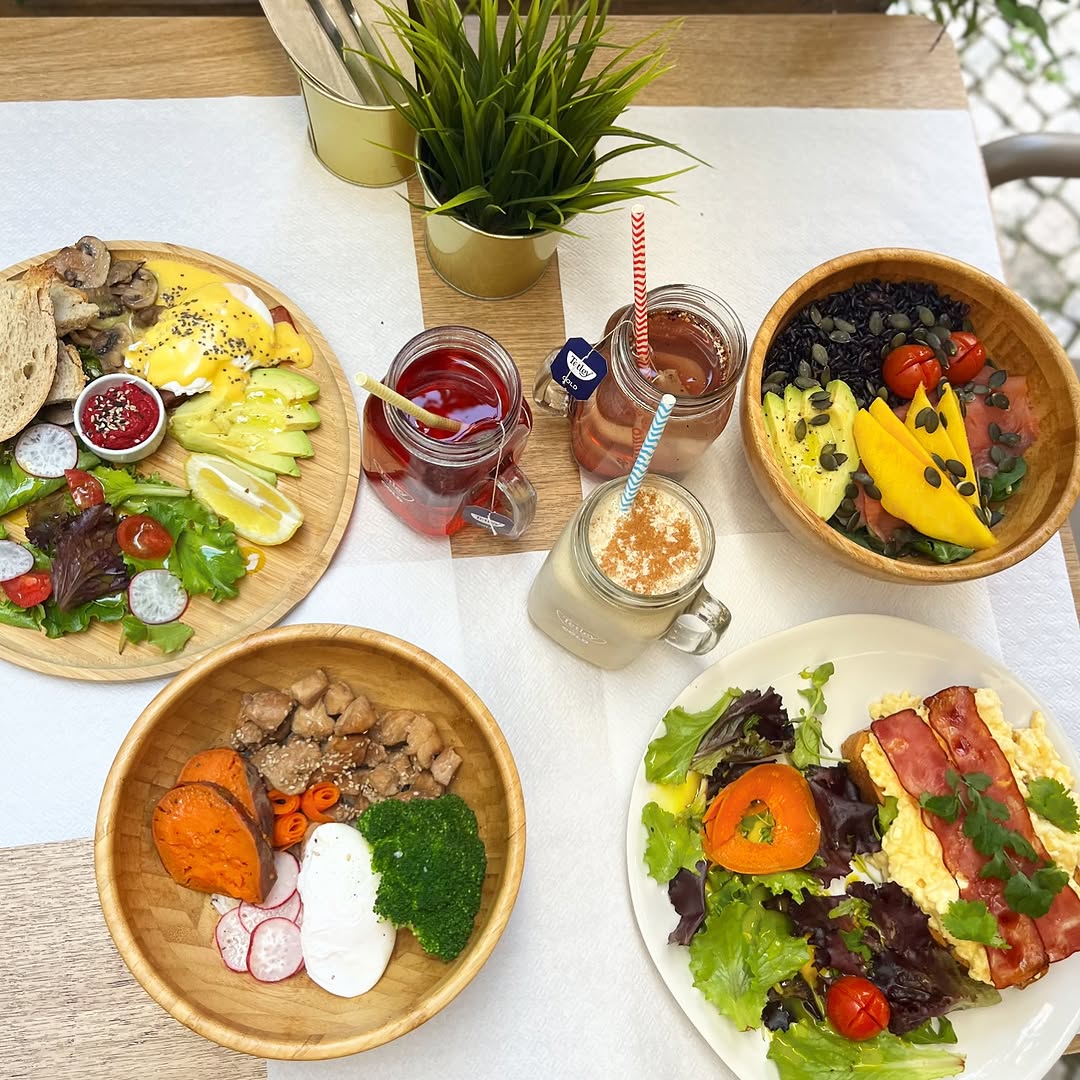 Mesa com vários pratos de brunch, saladas e taças de fruta, vista de cima